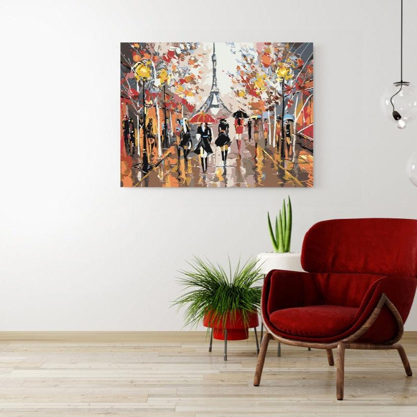 a red chair sitting in front of a painting on a wall